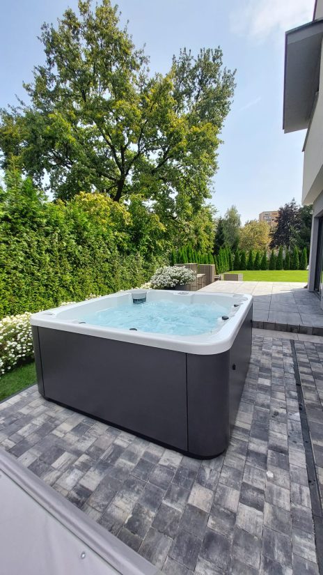 Wanna z hydromasażem na tarasie w ogrodzie.