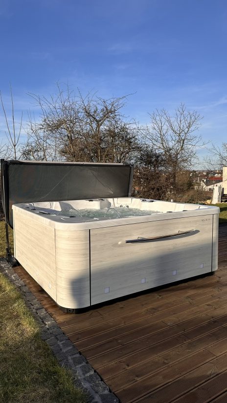 Wanna z hydromasażem Aquavia Spa na drewnianym tarasie w słoneczny dzień.
