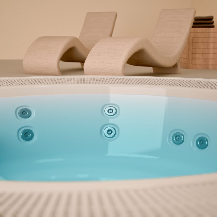 Wanna z hydromasażem i leżaki wypoczynkowe w strefie spa.