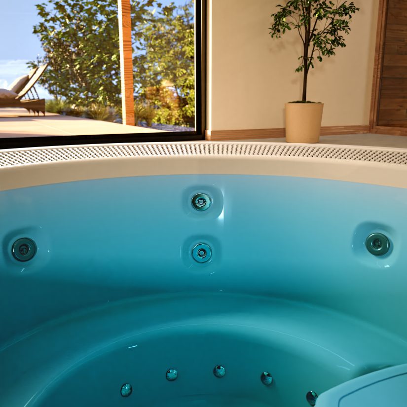 Wnętrze wanny z hydromasażem z widokiem na słoneczny taras i roślinność.