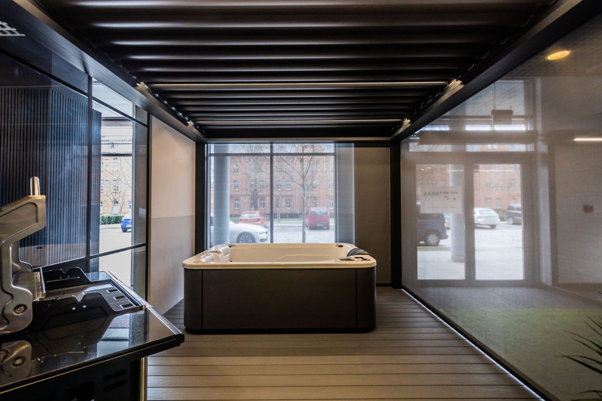 Wanna ogrodowa umieszczona na tarasie z zadaszeniem typu pergola i roletami typu screen.