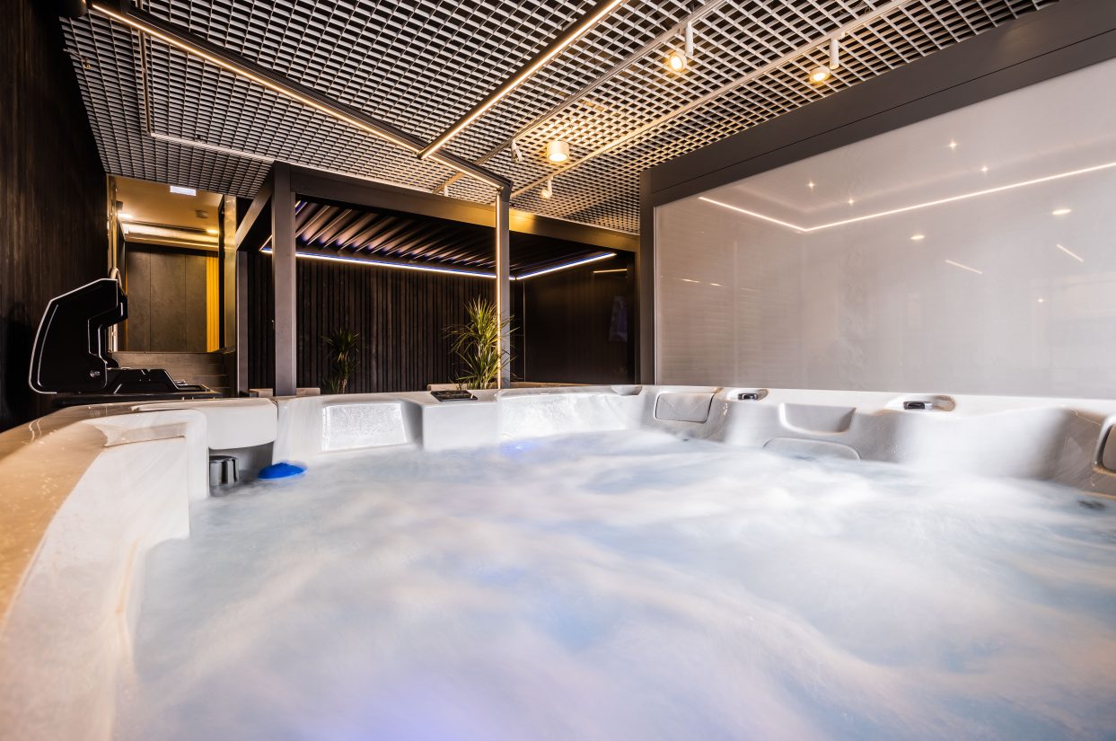 Nowoczesne jacuzzi z hydromasażem w eleganckim wnętrzu z podwieszanym sufitem.