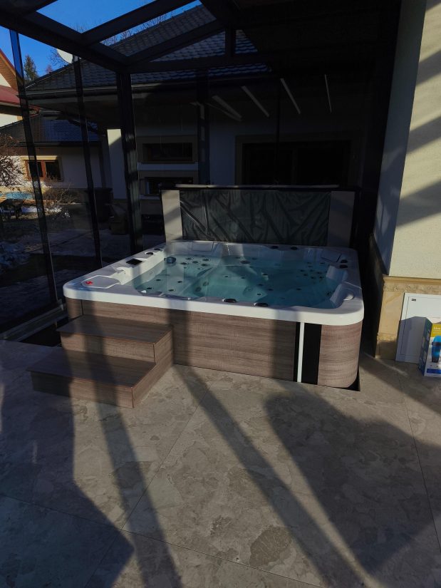 Wanna zewnętrzna z hydromasażem na zadaszonym tarasie.