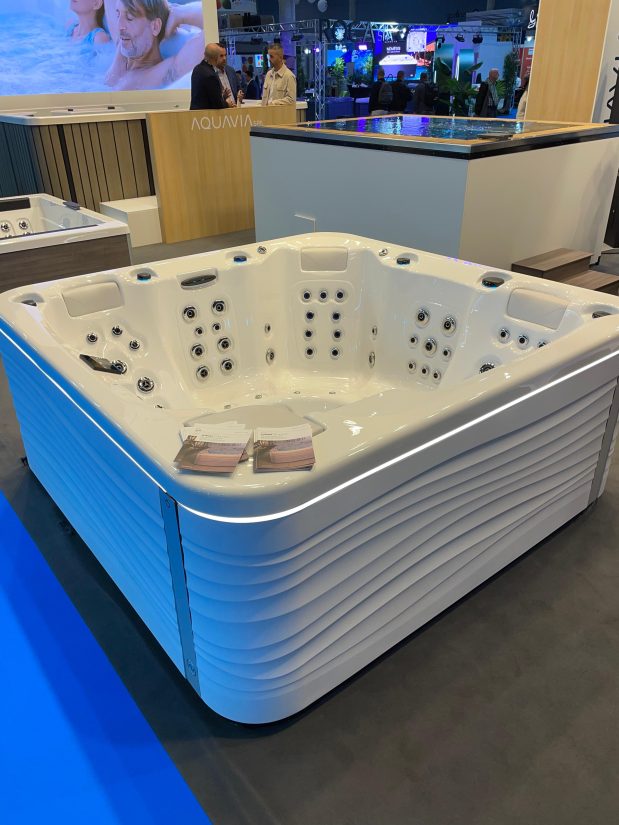 Biała wanna z hydromasażem marki Aquavia Spa z podświetleniem LED na targach branżowych.