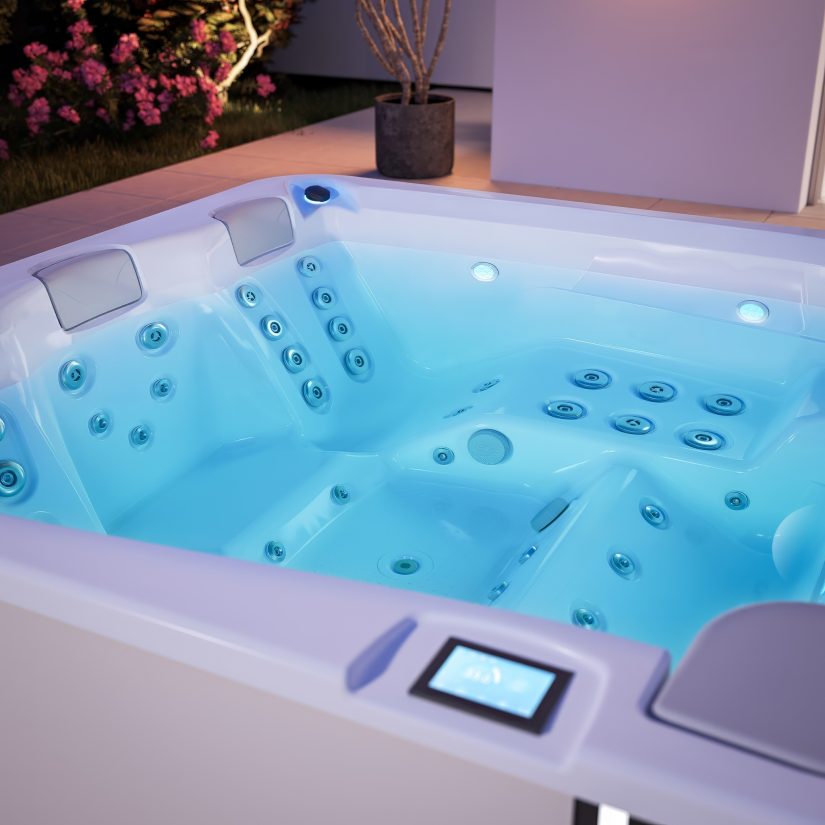 Podświetlane jacuzzi ogrodowe z panelem sterowania na krawędzi.